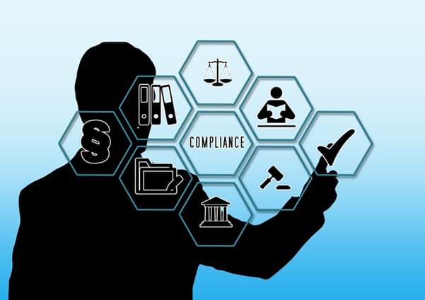 Two business professionals reviewing compliance documents in a modern office.